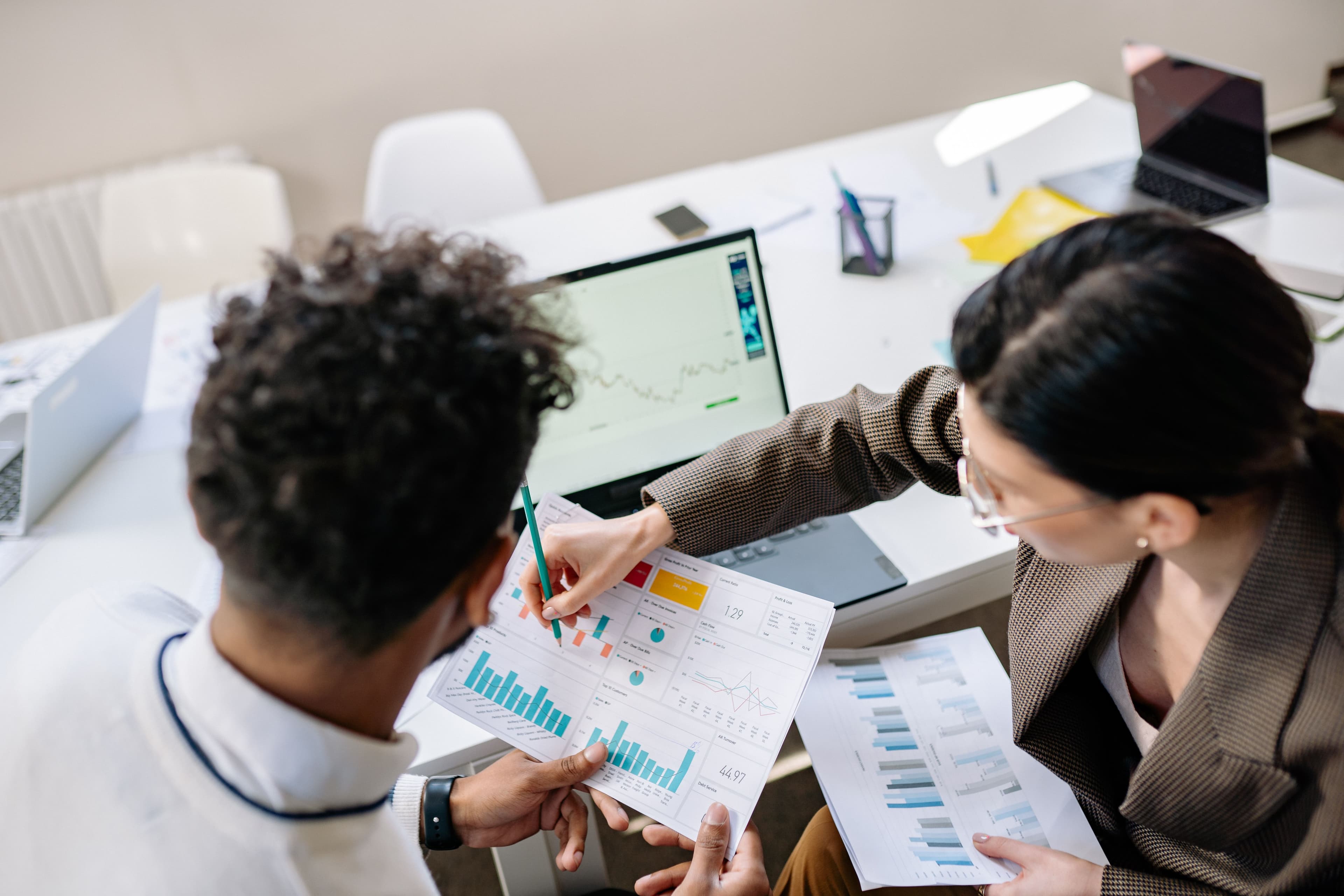 Deux professionnels analysant des graphiques de performance et des tableaux de bord de données