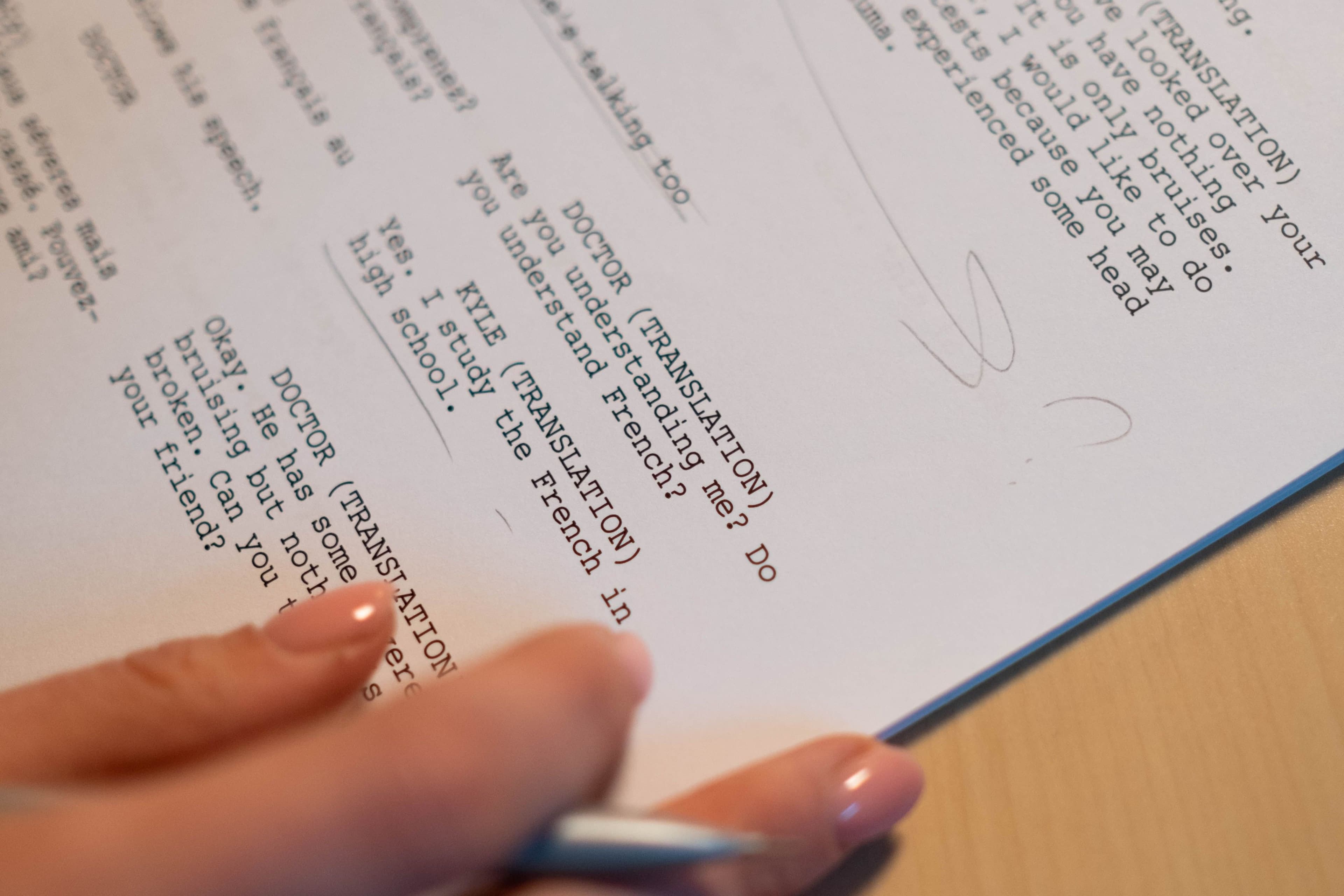 Main annotant au stylo un document imprimé lors d'une relecture éditoriale
